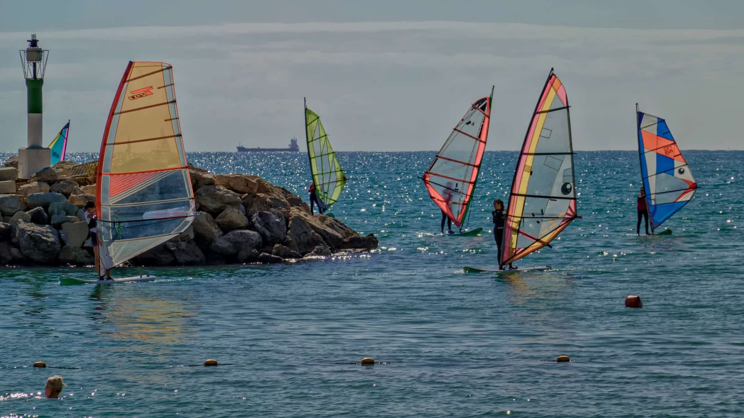A small windsurf group practising together on the water