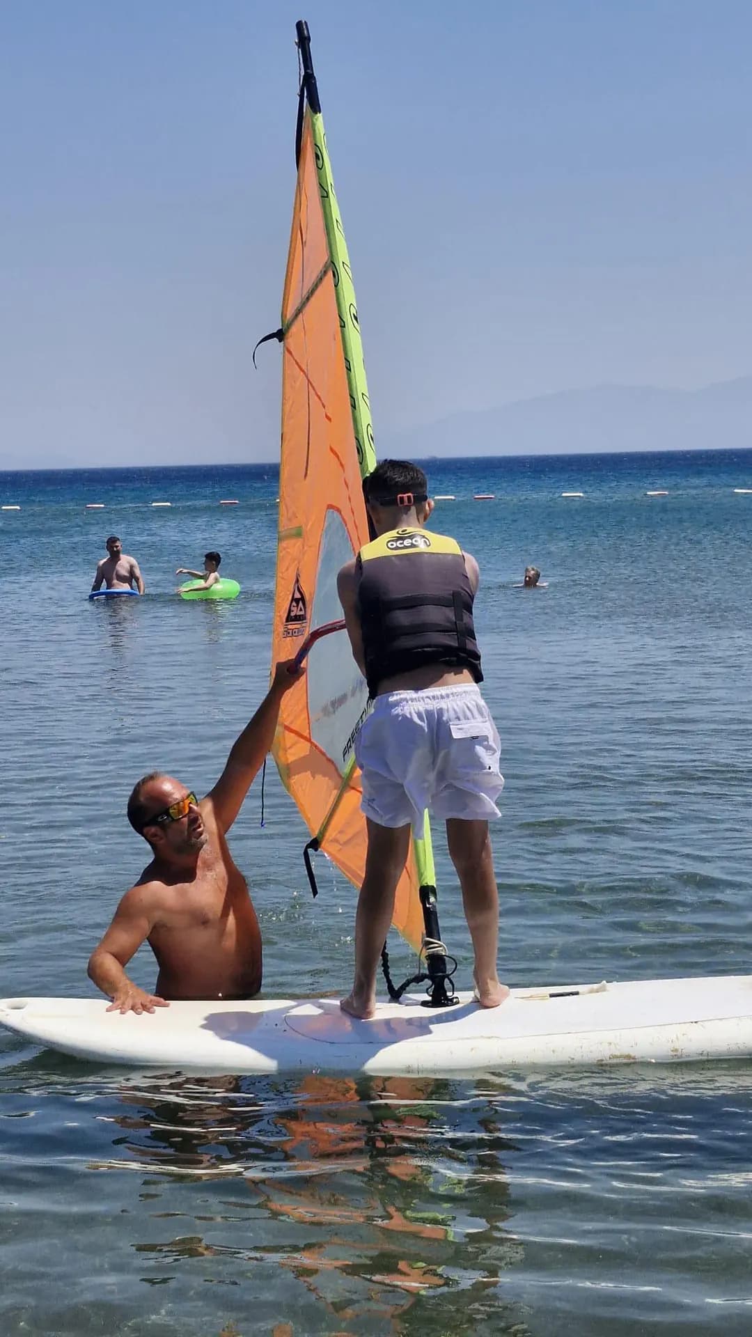 A windsurf participant working on sail control with an instructor at Vela