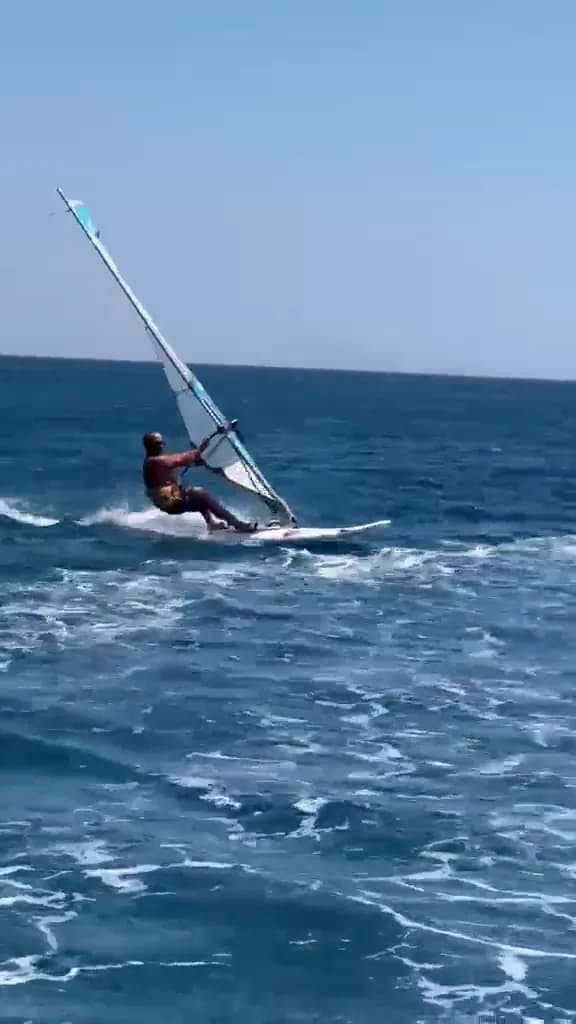 Bodrum açıklarında planing hızında ilerleyen windsurf sporcusu